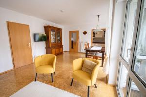 ein Wohnzimmer mit zwei gelben Stühlen und einem Tisch in der Unterkunft Am Feigenbaum in Albisheim