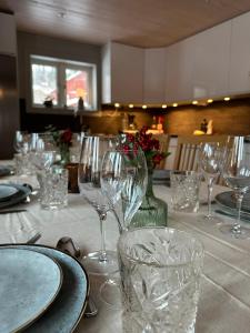 Una mesa con copas de vino y platos encima. en House in Åre Björnen ski-in ski-out, en Åre