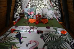 a bed with birds and flamingos on it at Msitu Hut in Tuvaila
