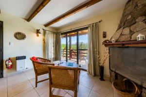 ein Wohnzimmer mit Kamin, Tisch und Stühlen in der Unterkunft Terrazas de Piedra in Santa Rosa de Calamuchita