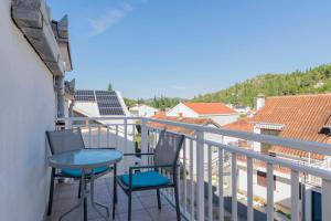 a balcony with two chairs and a table on it at Apartments Beach house Blace in Blace