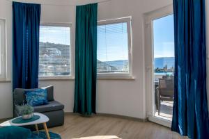a living room with blue curtains and a couch at Apartments Beach house Blace in Blace