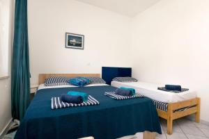 two twin beds in a room with green curtains at Apartments Beach house Blace in Blace +54 photos