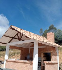 tenda da sole sopra un camino in mattoni in una casa di Finca La Esperanza Campestre Cucunuba a Cucunubá