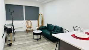 uma sala de estar com um sofá verde e uma mesa em Preston City centre Winckley Square Flat em Preston