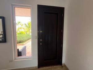 eine schwarze Tür in einem Raum mit einem Fenster in der Unterkunft Condo 1bdr 1bth with kitchen and garden in Punta Cana