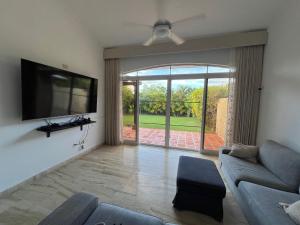 ein Wohnzimmer mit Couch und Flachbildfernseher in der Unterkunft Condo 1bdr 1bth with kitchen and garden in Punta Cana