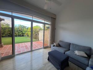ein Wohnzimmer mit Couch und großem Fenster in der Unterkunft Condo 1bdr 1bth with kitchen and garden in Punta Cana