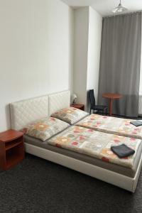a bedroom with a bed and a table and a chair at Loftel v centru Ostravy in Slezská Ostrava +13 photos