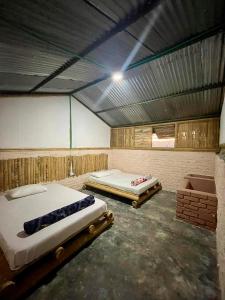 2 Betten in einem großen Zimmer mit einer Decke in der Unterkunft Tierra de Nubes in Melgar