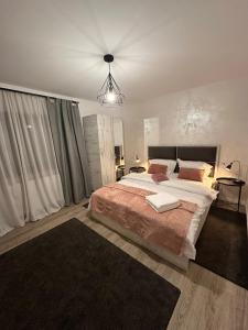 Un dormitorio con una cama grande y una lámpara de araña. en Chill Boutique Zamora, en Buşteni