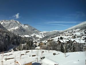 a snow covered village with houses and mountains at Mountain Living Apartment Idylia in Ortisei