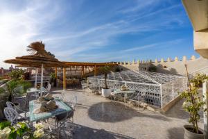 eine Terrasse mit Tischen und Stühlen und ein Gebäude in der Unterkunft Riad du Rabbin in Marrakesch