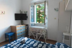 Un dormitorio con una cama y una ventana y un escritorio. en Paradiso blu Riva Trigoso, en Riva Trigoso