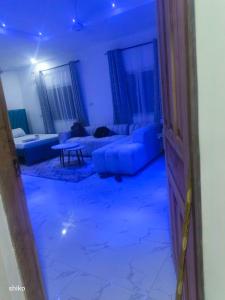 ein blaues Zimmer mit einem Sofa und einem Tisch in der Unterkunft TJ street studio apartment in Mtwapa