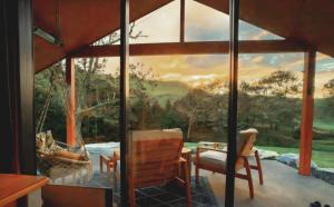 a room with a large window with a view at Ripples Retreat - Riverside Luxury in Piopio