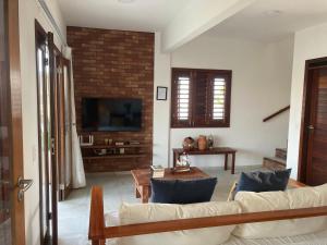 un soggiorno con un divano e una TV di Casa encanto dos corais a Trairi