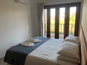 un letto con due cuscini sopra in una stanza con finestra di Casa encanto dos corais a Trairi Altre 21 foto