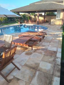 un gruppo di tavoli e sedie accanto alla piscina di Casa encanto dos corais a Trairi