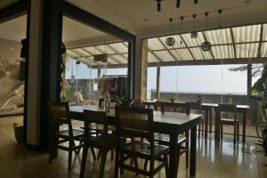 a dining room with a table and some chairs at The Stables Oceanfront Hotel Midigama in Midigama East