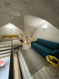 梅萨涅Suite La Madonnina的客厅里有一张蓝色沙发和一张床