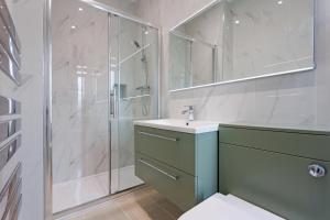 Un baño con ducha, lavabo e inodoro. en Savoy 5, en Ayr