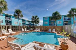 ein Swimmingpool mit Liegestühlen und ein Gebäude in der Unterkunft Lani Kai 123 in Gulf Shores