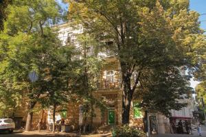 een groot gebouw met bomen ervoor bij Sadovaya Historical apartment in Odessa