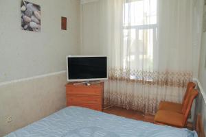 een slaapkamer met een tv op een dressoir en een raam bij Sadovaya Historical apartment in Odessa