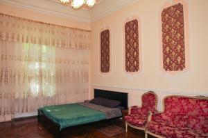 een slaapkamer met een bed, een bank en ramen bij Sadovaya Historical apartment in Odessa