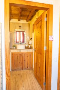 a bathroom with a sink and a wooden door at Hotel bugambilias in Valle de Bravo +48 photos
