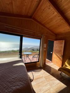 a bedroom with a bed and a balcony with a table at Cabañas BERGHAUS 