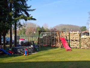 a park with a playground with a slide and logs at PRIMA Quartier in Lastrup