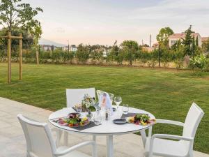 un tavolo bianco con sedie e piatti di cibo sopra di Mercure Hotel & Spa Bastia Biguglia a Biguglia