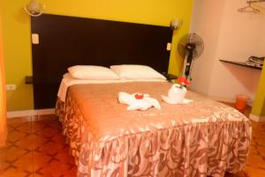 a bedroom with a bed with towels and a fan at Hotel Casa Real Tacna in Tacna