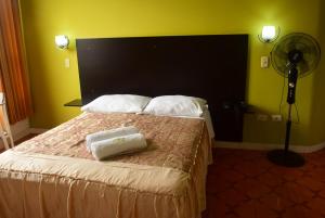 a bedroom with a bed with a large headboard and a fan at Hotel Casa Real Tacna in Tacna