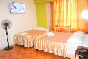a hotel room with two beds and a fan at Hotel Casa Real Tacna in Tacna