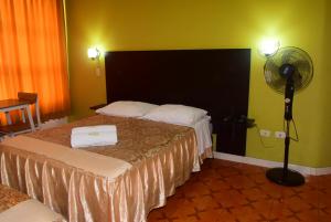 a hotel room with two beds and a fan at Hotel Casa Real Tacna in Tacna