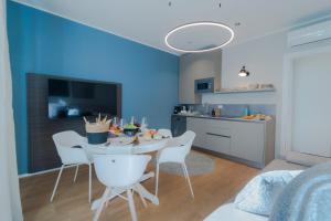 een woonkamer met een tafel en stoelen en een keuken bij Blue chic Suite CentroBergamo in Bergamo