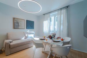 een woonkamer met een bank, een tafel en stoelen bij Blue chic Suite CentroBergamo in Bergamo