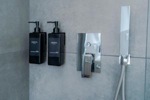 een badkamer met drie zeepdispensers aan de muur bij Blue chic Suite CentroBergamo in Bergamo +16 foto's