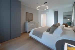 een slaapkamer met een wit bed en een dressoir bij Blue chic Suite CentroBergamo in Bergamo