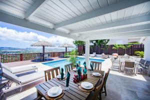 patio con tavolo e piscina di Stunning 4 bedroom villa a Saint John's