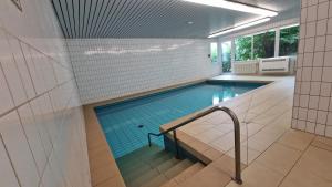 a swimming pool with a staircase in a building at Cozy Schwarzwaldnest für 2! in Schönwald