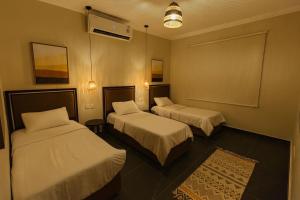 a hotel room with two beds and a rug at درة العروس - فن بيتش in Durat Alarous