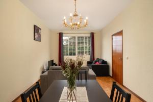 una sala da pranzo con tavolo e vaso di fiori di Vigário House a Câmara de Lobos