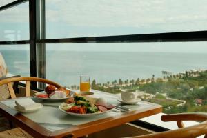 a table with two plates of food and a glass of orange juice at The Grandeur Hotel in Batumi +42 photos