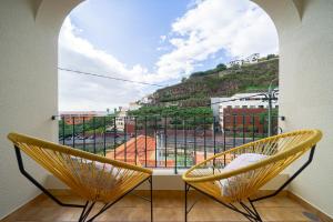 due sedie davanti a una finestra con vista di Vigário House a Câmara de Lobos