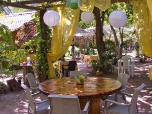 a table and chairs in a garden with a yellow curtain at Coco Encantado Eco Hostal Camping in Cartagena de Indias