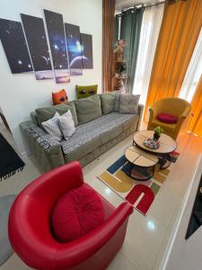 a living room with a couch and a red chair at Family Apartment in Niš